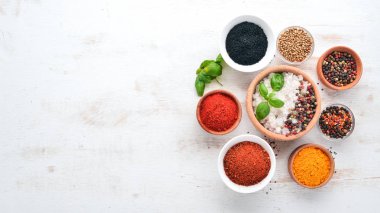 Baharat ve otlar Beyaz ahşap bir masa üzerinde bir dizi. Fesleğen, karabiber, safran, baharatlar. Hint geleneksel mutfak. Üstten görünüm. Ücretsiz kopya alanı.