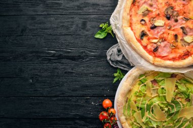 İtalyan pizza kümesi. İtalyan mutfağı. Siyah ahşap arka plan üzerinde. Ücretsiz kopya alanı. Üstten görünüm.