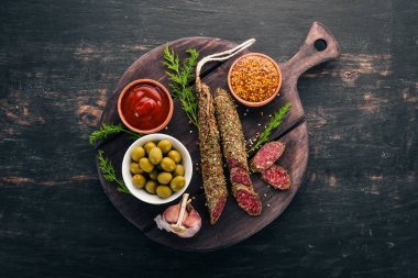 Sosis Fuet. Salam baharatlar ile. Siyah bir arka plan üzerinde. Üstten görünüm. Metniniz için boş alan.