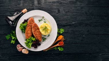 Pirzola et bir tabak patates püresi ile. Eski ahşap arka plan üzerinde. Metin için özgür yer. Üstten görünüm.