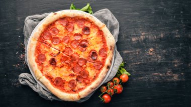 Sosis ve domates sosu ile pizza Margarita. Ahşap bir arka plan üzerinde. Üstten görünüm. Metniniz için boş alan.