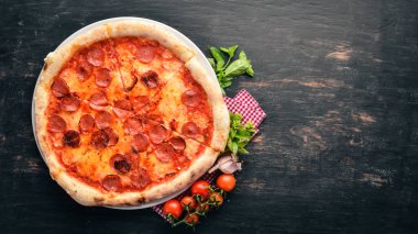 Sosis ve domates sosu ile pizza Margarita. Ahşap bir arka plan üzerinde. Üstten görünüm. Metniniz için boş alan.