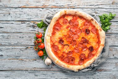 Sosis ve domates sosu ile pizza Margarita. Ahşap bir arka plan üzerinde. Üstten görünüm. Metniniz için boş alan.