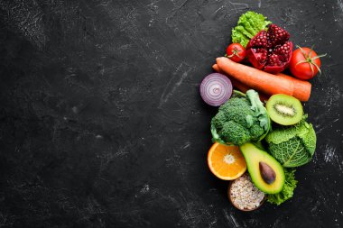 Siyah taşlı arka planda organik yiyecekler. Sebze ve meyve. Üst Manzara. Boş kopyalama alanı.