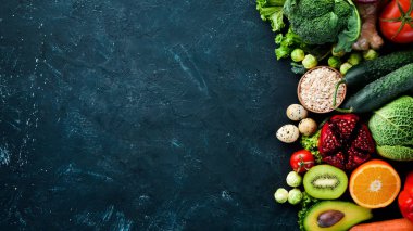 Siyah taşlı arka planda organik yiyecekler. Sebze ve meyve. Üst Manzara. Boş kopyalama alanı.