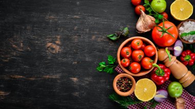 Bitkisel arka plan. Masaya taze domates, biber, soğan ve maydanoz. Üst görünüm. Siyah bir arka planda. Metin için boş alan.