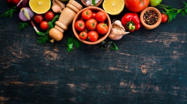 Bitkisel arka plan. Masaya taze domates, biber, soğan ve maydanoz. Üst görünüm. Siyah bir arka planda. Metin için boş alan.