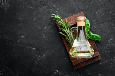 Siyah taş arka planda bir kavanozda zeytin yağı. Üst görünüm. Metniniz için boş alan.