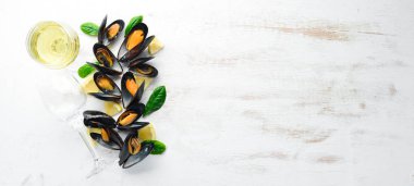 Bir şişe beyaz şarap ve midye. Üst görünüm. Metniniz için boş alan. Eski arka planda.