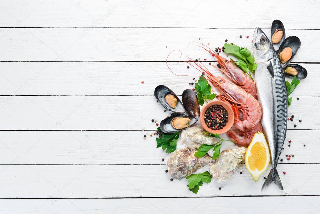 Seafood on a white wooden background. Fresh fish, shrimp, oysters and caviar. Top view. Free copy space.