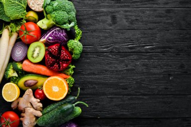 Taze sebze ve meyveler. Organik gıda siyah ahşap zemin. Üstten Görünüm. Ücretsiz kopya alanı.