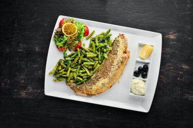 Fırında Balık. Alabalık ile yeşil fasulye pişirdim. Ahşap bir arka plan üzerinde. Üstten Görünüm. Ücretsiz kopya alanı