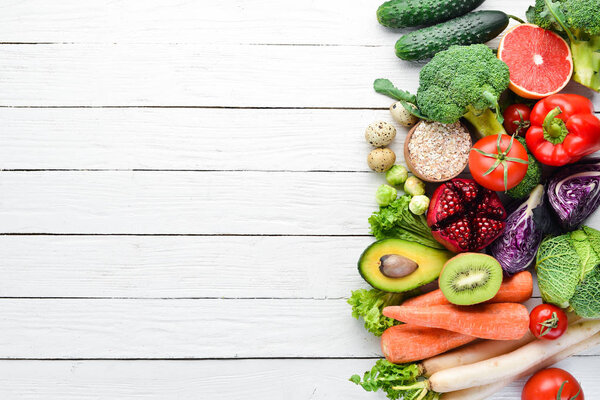 Fresh vegetables and fruits on a white wooden background. Healthy Organic Food. Top view. Free copy space.