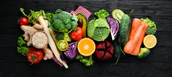 Fresh vegetables and fruits. Organic food on a black wooden background. Top view. Free copy space.