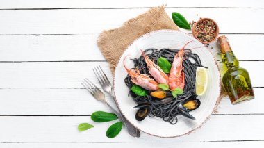 Siyah spagetti. Deniz ürünleri ve limon ile siyah makarnalar. Karides ve midye. Eski arka plan üzerinde. Üstten Görünüm. Metniniz için boş alan.