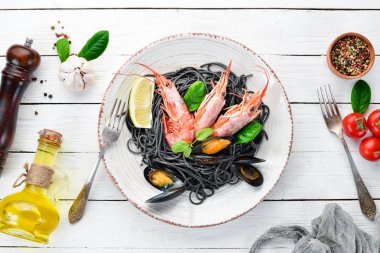 Siyah spagetti. Deniz ürünleri ve limon ile siyah makarnalar. Karides ve midye. Eski arka plan üzerinde. Üstten Görünüm. Metniniz için boş alan.