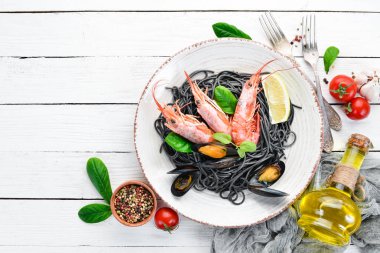 Siyah spagetti. Deniz ürünleri ve limon ile siyah makarnalar. Karides ve midye. Eski arka plan üzerinde. Üstten Görünüm. Metniniz için boş alan.