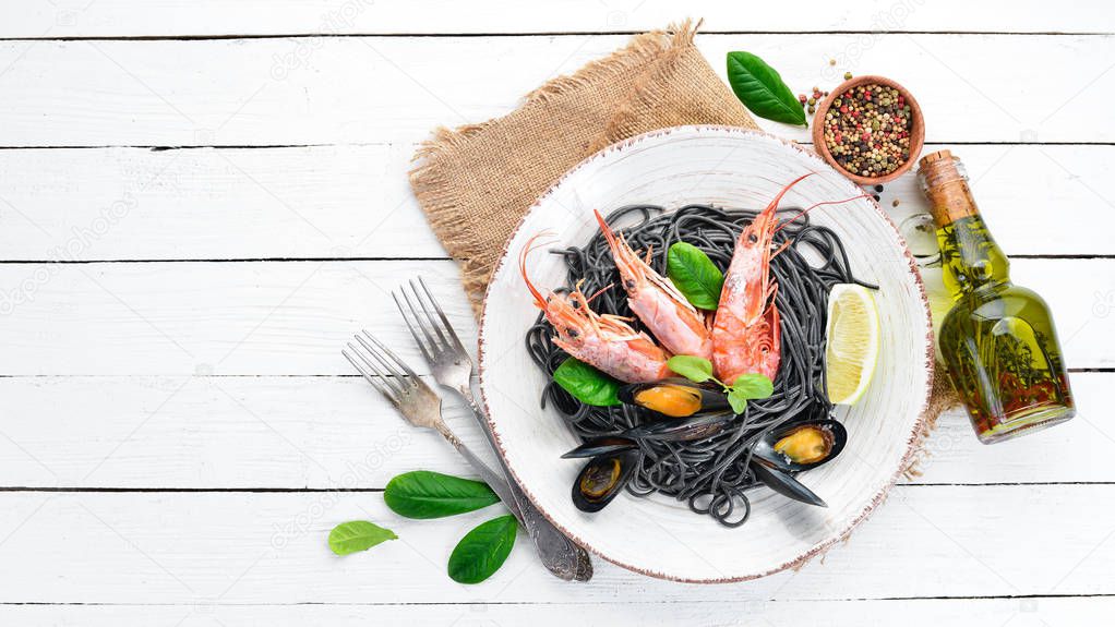 Black spaghetti. Black pastas with seafood and lemon. Shrimp and mussels. On the old background. Top view. Free space for your text.