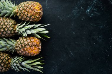 Siyah bir taş zemin üzerine taze ananas. Üstten Görünüm. Ücretsiz kopya alanı.