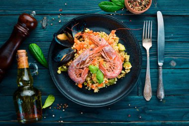 Bulgur karides, midye ve sebze. Eski arka plan üzerinde. Üstten Görünüm. Metniniz için boş alan.