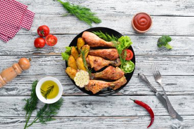 Patates ve sebze siyah taş zemin ile pişmiş tavuk budu. Et. Üstten Görünüm. Ücretsiz kopya alanı.