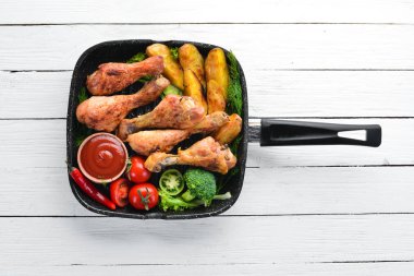 Patates ve sebze siyah taş zemin ile pişmiş tavuk budu. Et. Üstten Görünüm. Ücretsiz kopya alanı.