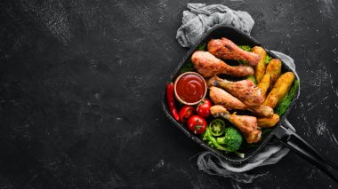 Patates ve sebze siyah taş zemin ile pişmiş tavuk budu. Et. Üstten Görünüm. Ücretsiz kopya alanı.