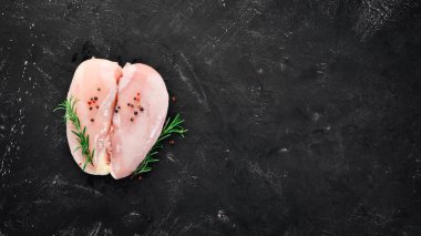 Baharat ve otlar ile çiğ tavuk göğsü. Barbekü. Siyah taş arka plan üzerinde. Üstten Görünüm. Ücretsiz kopya alanı.