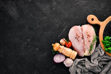 Baharat ve otlar ile çiğ tavuk göğsü. Barbekü. Siyah taş arka plan üzerinde. Üstten Görünüm. Ücretsiz kopya alanı.