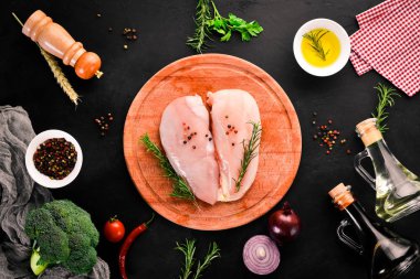 Baharat ve otlar ile çiğ tavuk göğsü. Barbekü. Siyah taş arka plan üzerinde. Üstten Görünüm. Ücretsiz kopya alanı.