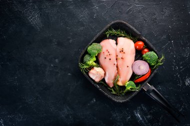 Baharat ve otlar ile çiğ tavuk göğsü. Barbekü. Siyah taş arka plan üzerinde. Üstten Görünüm. Ücretsiz kopya alanı.