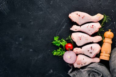 Çiğ tavuk budu ve baharat ve otlar. Barbekü. Beyaz ahşap zemin üzerinde. Üstten Görünüm. Ücretsiz kopya alanı.