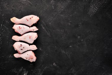 Çiğ tavuk budu ve baharat ve otlar. Barbekü. Beyaz ahşap zemin üzerinde. Üstten Görünüm. Ücretsiz kopya alanı.