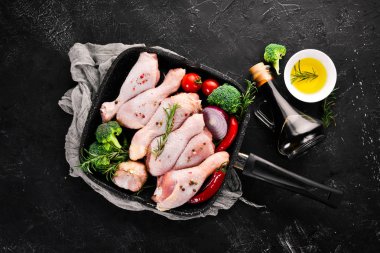 Çiğ tavuk budu ve baharat ve otlar. Barbekü. Beyaz ahşap zemin üzerinde. Üstten Görünüm. Ücretsiz kopya alanı.