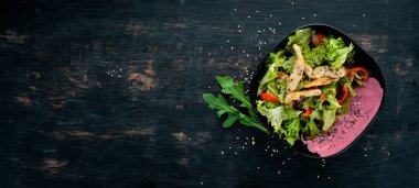 Sebze ve Tavuk salatası. Ahşap bir arka plan üzerinde. Üstten Görünüm. Metniniz için boş alan.