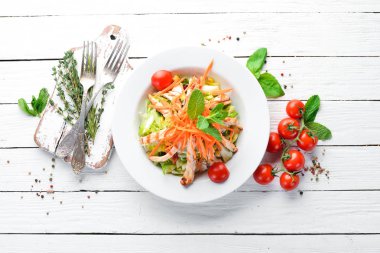 Tavuk ve beyaz bir arka planda tahta taze sebze salatası. Metniniz için boş alan. Üstten Görünüm.