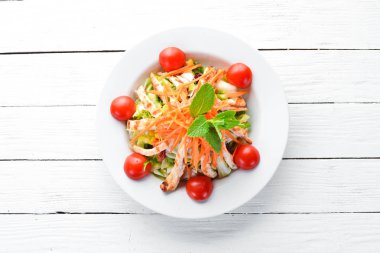 Tavuk ve beyaz bir arka planda tahta taze sebze salatası. Metniniz için boş alan. Üstten Görünüm.