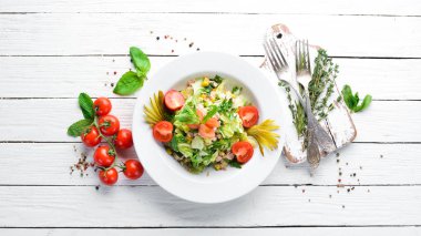 Ton balıklı salata ve Beyaz ahşap zemin üzerinde taze sebze. Metniniz için boş alan. Üstten Görünüm.