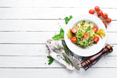 Ton balıklı salata ve Beyaz ahşap zemin üzerinde taze sebze. Metniniz için boş alan. Üstten Görünüm.