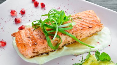 Bir tabakta sebze ile pişmiş somon fileto. Ahşap bir arka plan üzerinde. Üstten Görünüm. Metniniz için boş alan.