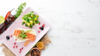 Bir tabakta sebze ile pişmiş somon fileto. Ahşap bir arka plan üzerinde. Üstten Görünüm. Metniniz için boş alan.