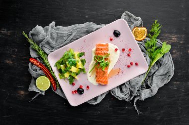 Bir tabakta sebze ile pişmiş somon fileto. Ahşap bir arka plan üzerinde. Üstten Görünüm. Metniniz için boş alan.