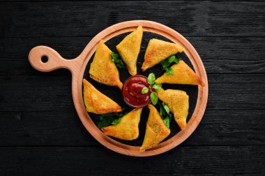 Asya gıda. Samsa et ve domates sos ile. Ahşap bir arka plan üzerinde. Üstten Görünüm. Ücretsiz kopya alanı.