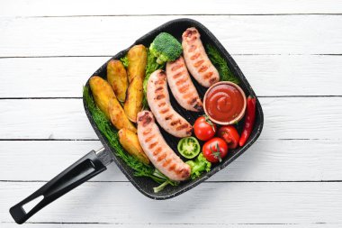 Patates ve sebze siyah taş zemin ile ızgara sosis. Et. Üstten Görünüm. Ücretsiz kopya alanı.