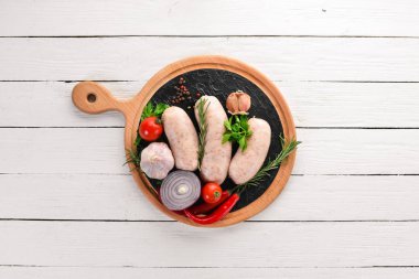 Baharat ve otlar ile çiğ sosis. Barbekü. Siyah taş arka plan üzerinde. Üstten Görünüm. Ücretsiz kopya alanı.