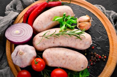 Baharat ve otlar ile çiğ sosis. Barbekü. Siyah taş arka plan üzerinde. Üstten Görünüm. Ücretsiz kopya alanı.