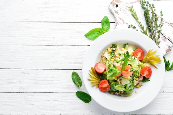 Ton balıklı salata ve Beyaz ahşap zemin üzerinde taze sebze. Metniniz için boş alan. Üstten Görünüm.