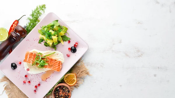 Bir tabakta sebze ile pişmiş somon fileto. Ahşap bir arka plan üzerinde. Üstten Görünüm. Metniniz için boş alan.