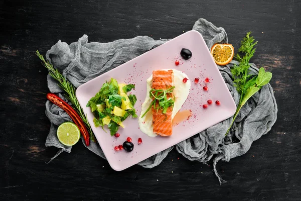 Bir tabakta sebze ile pişmiş somon fileto. Ahşap bir arka plan üzerinde. Üstten Görünüm. Metniniz için boş alan.