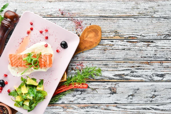 Bir tabakta sebze ile pişmiş somon fileto. Ahşap bir arka plan üzerinde. Üstten Görünüm. Metniniz için boş alan.